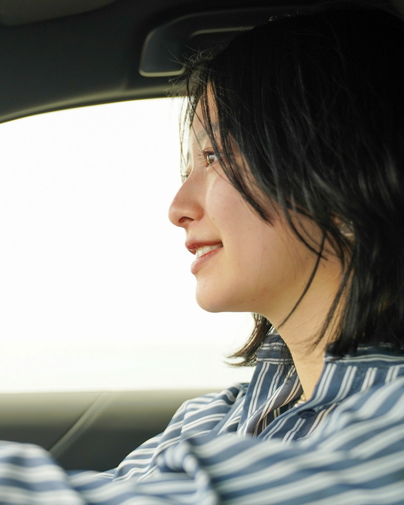 笑顔で車を運転する女性